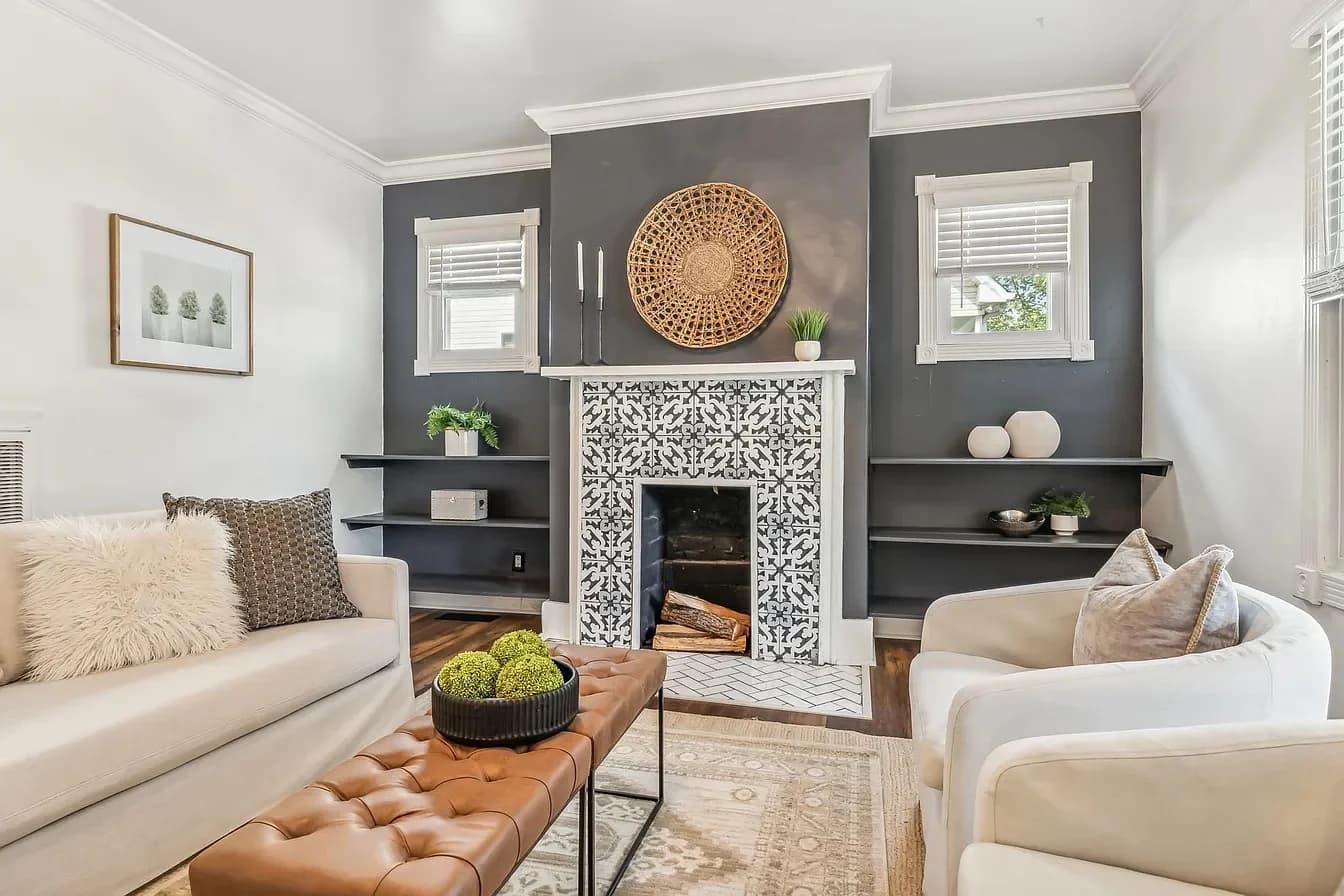 Living room with a patterned tile fireplace, a charcoal accent wall, and a cognac leather coffee table